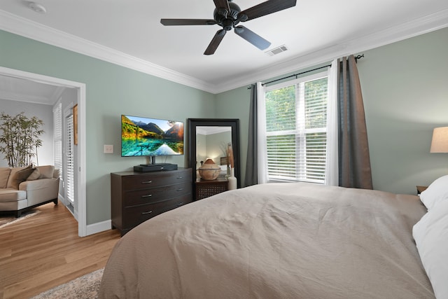 bedroom featuring ceiling fan, light wood-type flooring, and ornamental molding