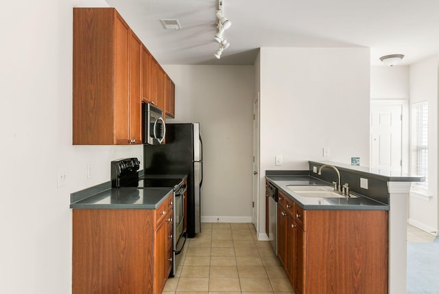 kitchen featuring rail lighting, sink, light tile patterned floors, and stainless steel appliances