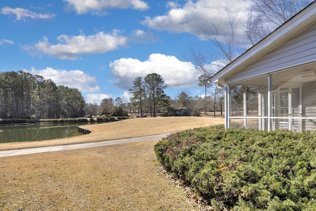 view of yard with a water view and a sunroom