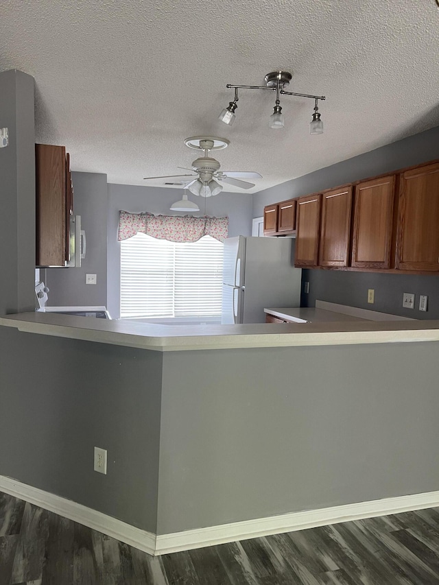 214 Hardee Ave, Summerville, SC 29485 - kitchen with freestanding refrigerator, brown cabinetry, stainless steel microwave, ceiling fan, and dark wood-style flooring