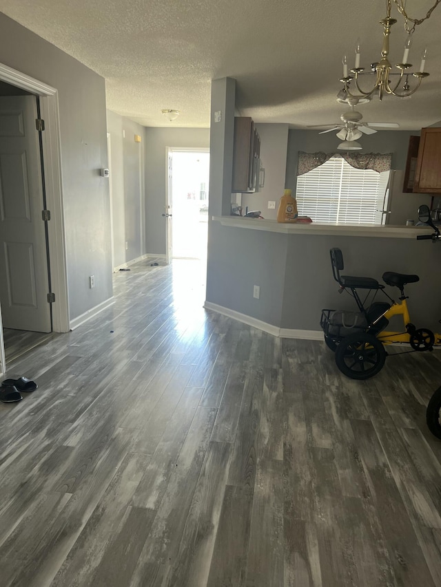 214 Hardee Ave, Summerville, SC 29485 - unfurnished living room featuring a textured ceiling, dark wood-style floors, baseboards, and ceiling fan with notable chandelier