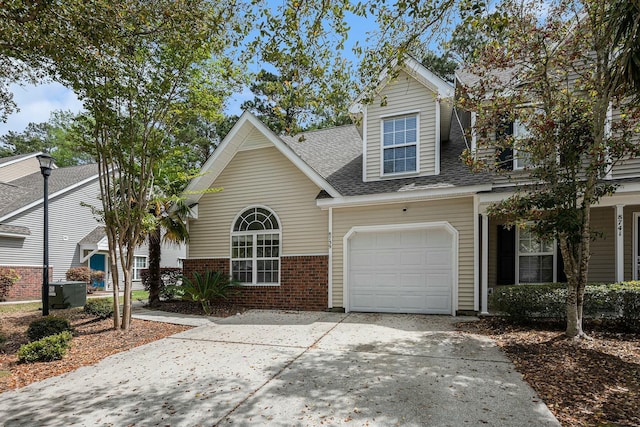 view of front of house featuring a garage, roof with shingles, driveway, and brick siding