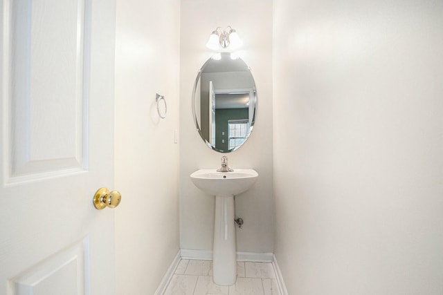 bathroom with baseboards and marble finish floor