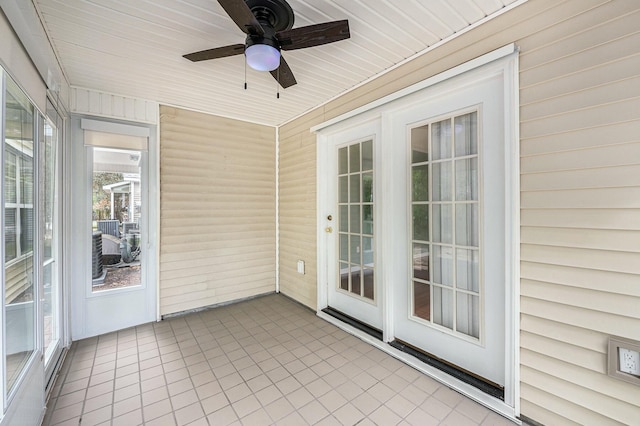 unfurnished sunroom featuring a ceiling fan