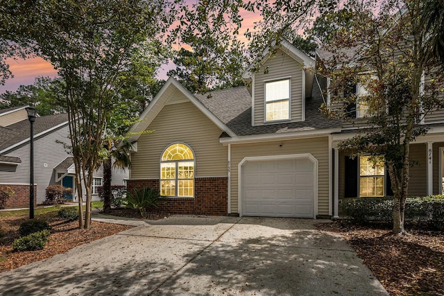 view of front of property featuring concrete driveway, roof with shingles, brick siding, and an attached garage