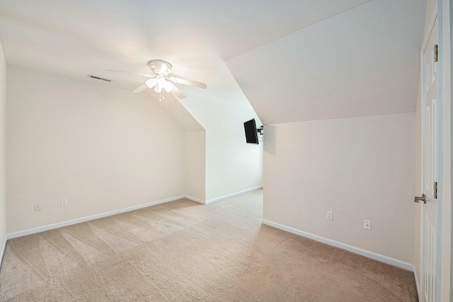 additional living space with visible vents, light colored carpet, a ceiling fan, and lofted ceiling