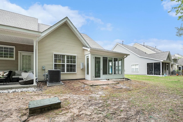 back of house with a sunroom, roof with shingles, and central AC