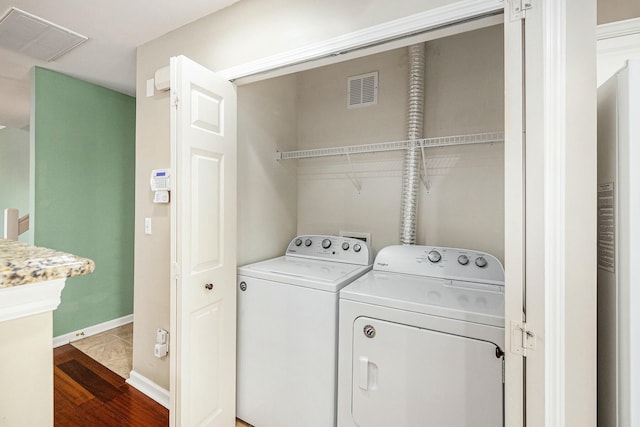 laundry room featuring separate washer and dryer, laundry area, visible vents, and dark wood finished floors