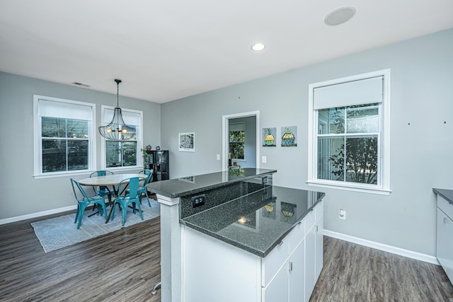 kitchen featuring a chandelier, a center island, white cabinetry, decorative light fixtures, and dark hardwood / wood-style flooring