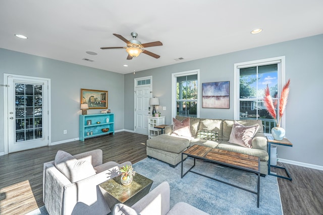 living room featuring ceiling fan and dark hardwood / wood-style floors