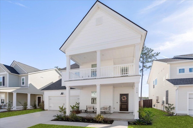 view of front of house with a garage, a balcony, a front yard, and covered porch