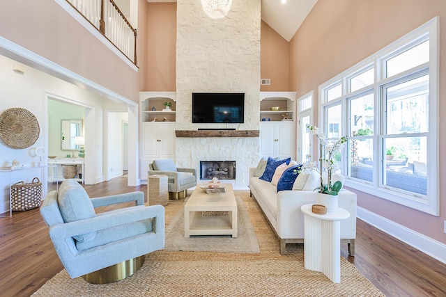 3130 Pignatelli Cres, Mount Pleasant, SC 29466 - living room featuring high vaulted ceiling, plenty of natural light, wood finished floors, a stone fireplace, and baseboards