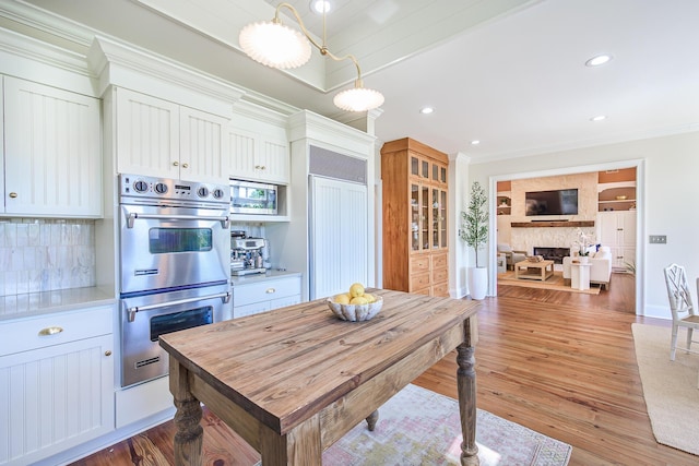 3130 Pignatelli Cres, Mount Pleasant, SC 29466 - kitchen featuring built in appliances, decorative backsplash, light countertops, a fireplace, and light wood-type flooring