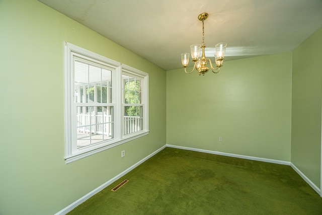 spare room with an inviting chandelier and dark carpet