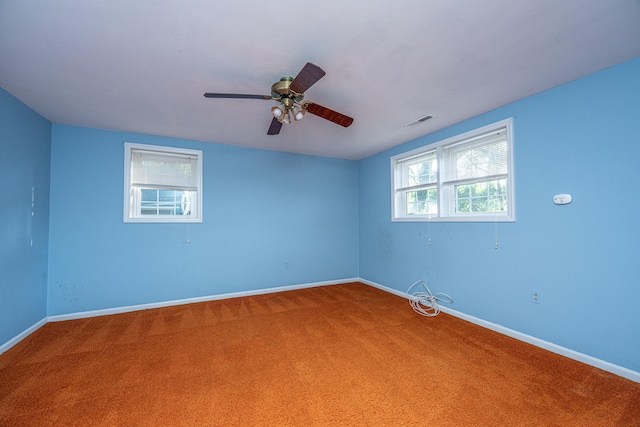 spare room with a wealth of natural light, carpet, and ceiling fan