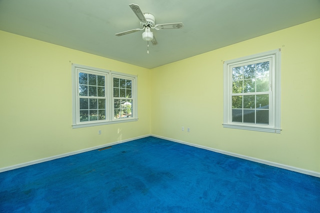 empty room featuring dark colored carpet and ceiling fan