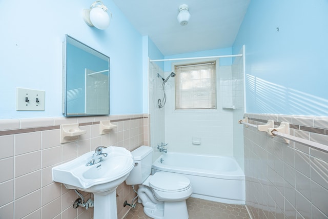 full bathroom with toilet, tile patterned floors, tile walls, lofted ceiling, and tiled shower / bath