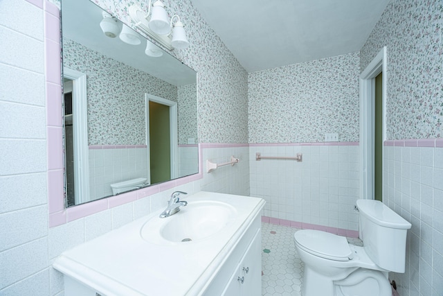 bathroom featuring vanity, tile walls, toilet, and tile patterned flooring