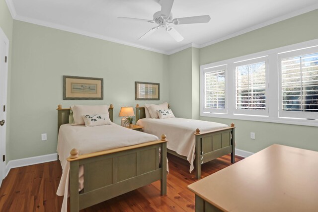 bedroom with baseboards, multiple windows, wood finished floors, and ornamental molding