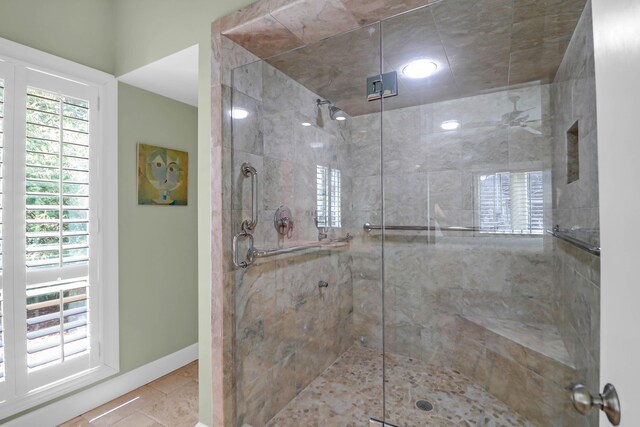 full bath with a shower stall and baseboards