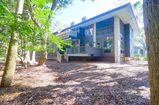 back of property featuring a deck, crawl space, and a chimney