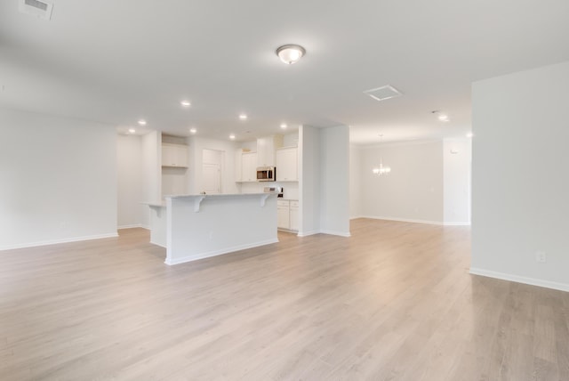 unfurnished living room featuring a chandelier, recessed lighting, visible vents, and light wood-style flooring