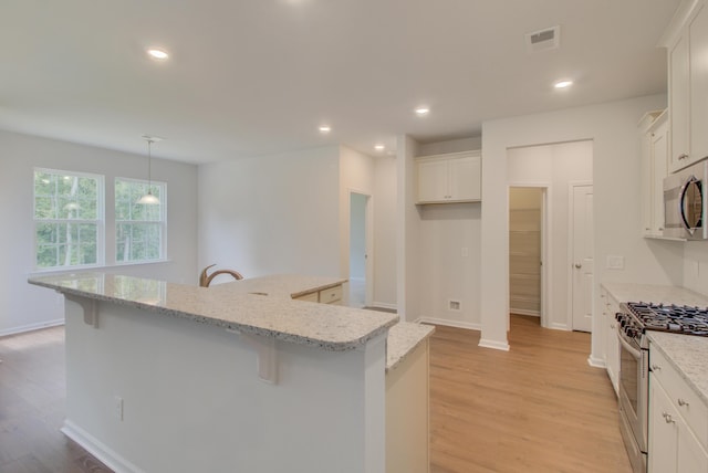 kitchen featuring a large island, recessed lighting, visible vents, appliances with stainless steel finishes, and light wood-style floors