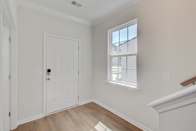 entryway featuring ornamental molding, wood finished floors, visible vents, and baseboards