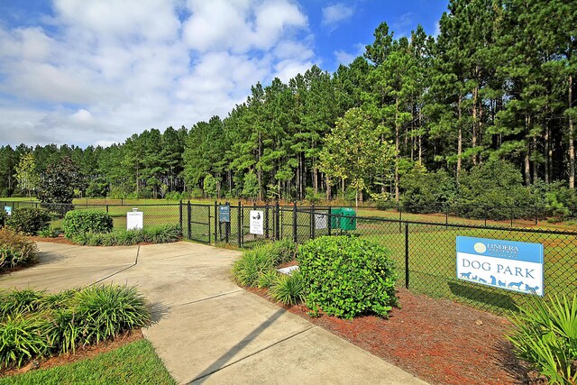 view of home's community with a lawn, fence, and a gate