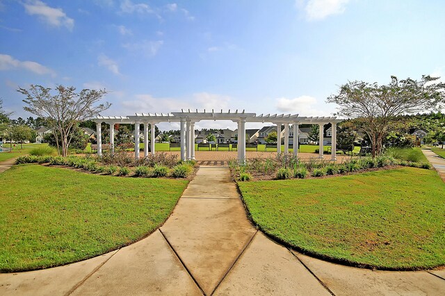 view of home's community featuring a pergola and a yard