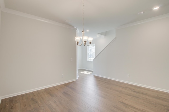 spare room featuring baseboards, ornamental molding, wood finished floors, and recessed lighting