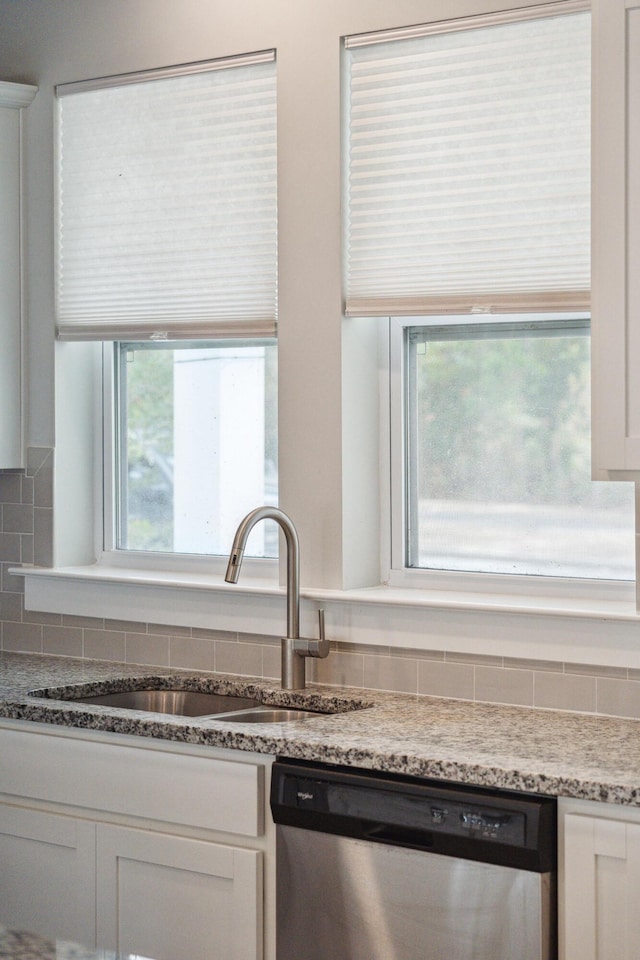 kitchen with white cabinetry, a wealth of natural light, dishwasher, and sink