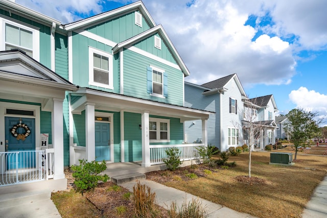 view of front of property featuring central AC unit, a porch, and a front yard