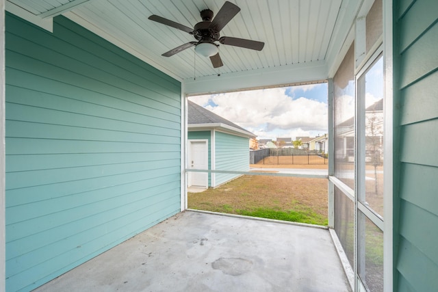 unfurnished sunroom featuring ceiling fan