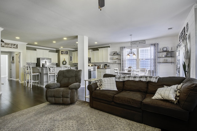 living room with crown molding and dark wood-type flooring