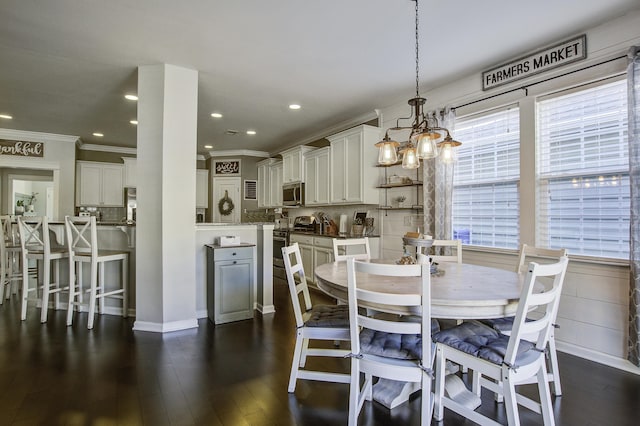 dining area featuring dark hardwood / wood-style flooring, ornamental molding, and an inviting chandelier