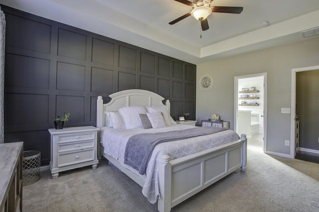 carpeted bedroom featuring ceiling fan and a tray ceiling