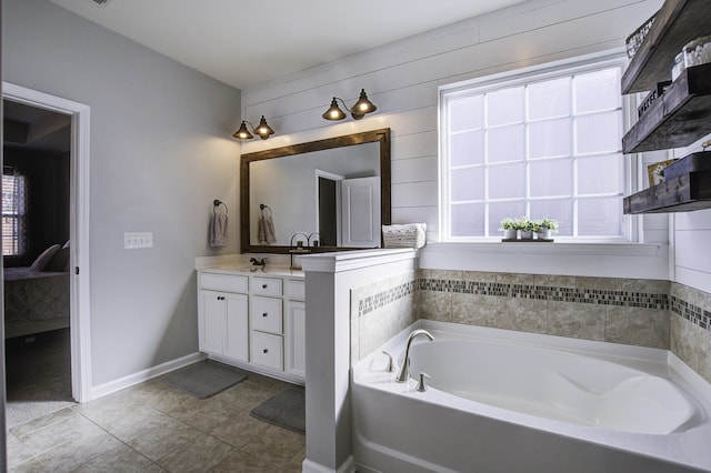 bathroom with vanity, a washtub, a wealth of natural light, and tile patterned floors