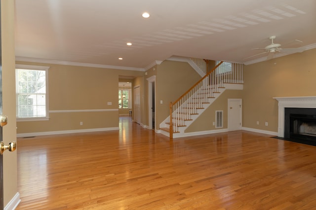 unfurnished living room with ornamental molding, light wood-type flooring, and ceiling fan