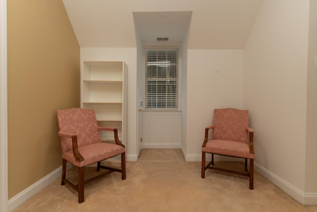 sitting room featuring light colored carpet and vaulted ceiling