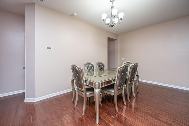 dining space with an inviting chandelier and dark hardwood / wood-style flooring