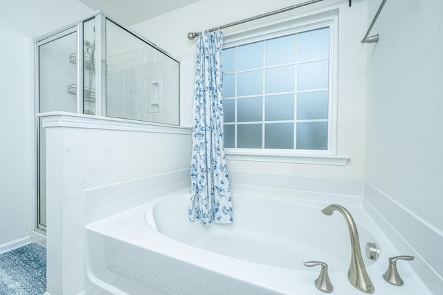 bathroom featuring shower with separate bathtub