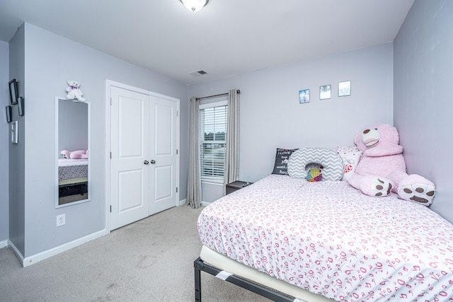 bedroom featuring light colored carpet and a closet