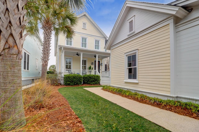 exterior space featuring ceiling fan, covered porch, and a front lawn