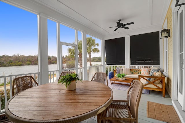 sunroom / solarium featuring ceiling fan and a water view