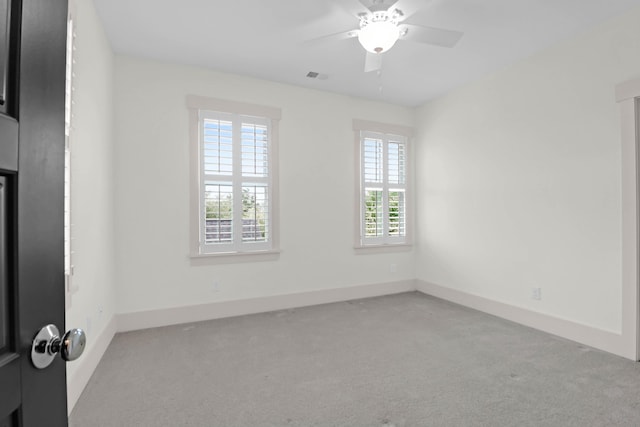 spare room featuring light carpet and ceiling fan