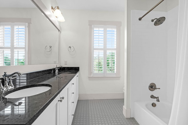 bathroom with tile patterned floors, vanity, and tiled shower / bath