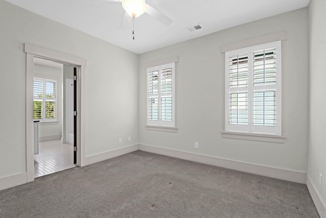 carpeted spare room with ceiling fan and a healthy amount of sunlight