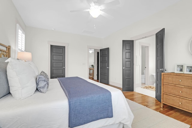 bedroom featuring hardwood / wood-style floors, ensuite bath, and ceiling fan