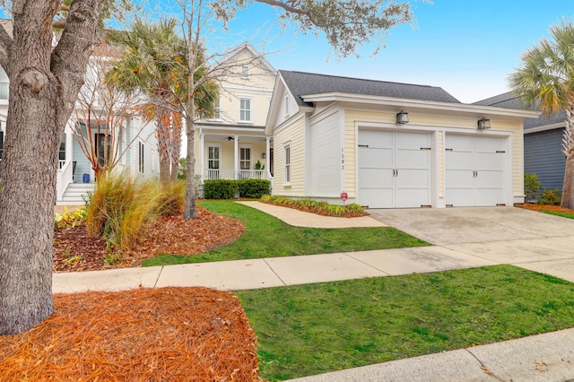 view of front of house featuring covered porch, a front yard, and a garage